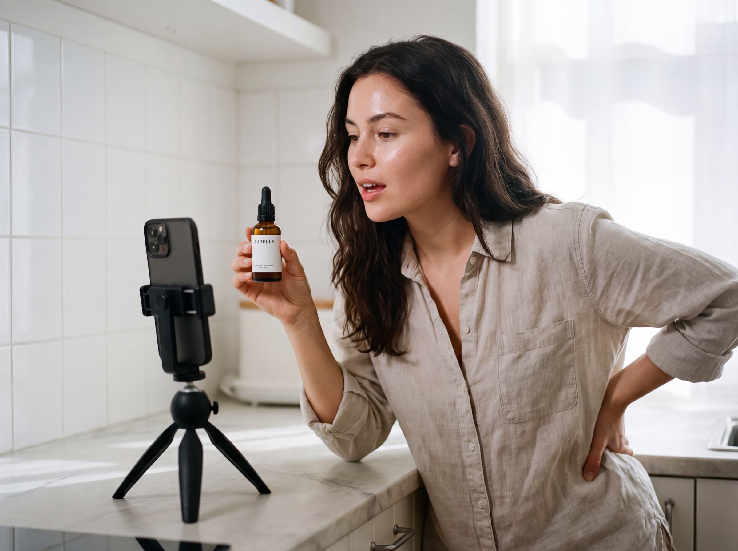 Creator recording herself at a kitchen counter holding an AURELLE serum