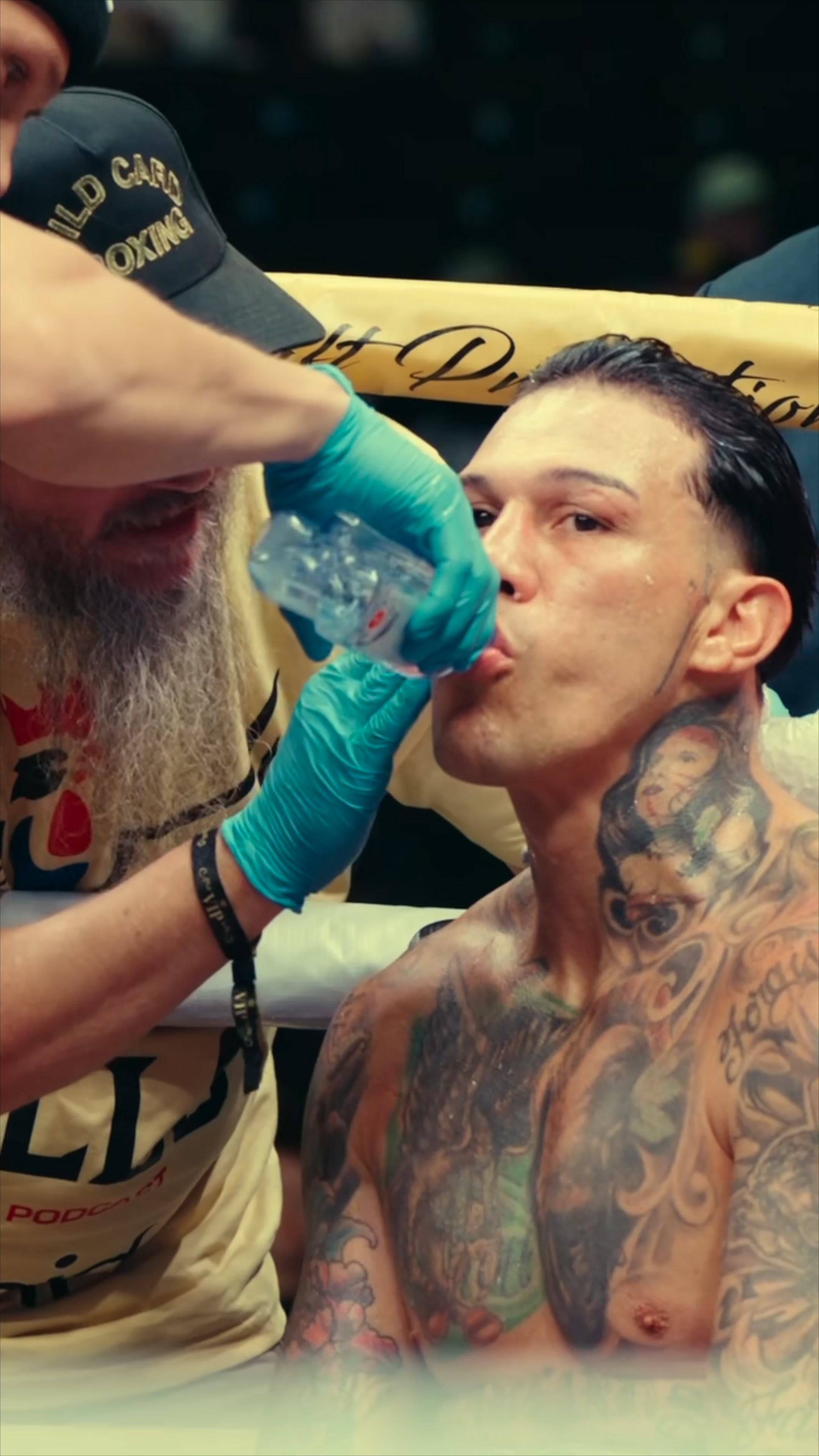 Fighter drinking from a One Water bottle in his corner at fight night